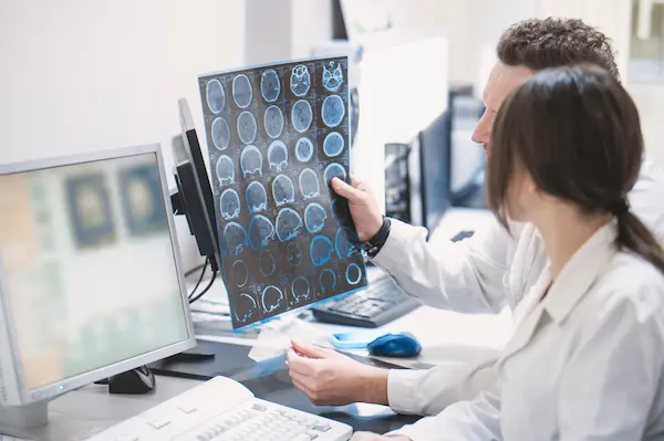 Two doctors discuss the results of an MRI scan on someone's musculoskeletal syystem.